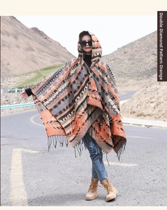 Détail du poncho à capuche ethnique orange à motif losanges avec franges pour voyage