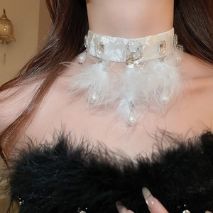 Detail of velvet choker featuring crystal accents, white feathers, and elegant pearls