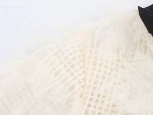 Vue macro du tissu en dentelle blanc cassé montrant la texture et le tissage respirant