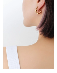 Close-up of a model wearing the beaded gold hoop earrings made of 18k plated titanium steel