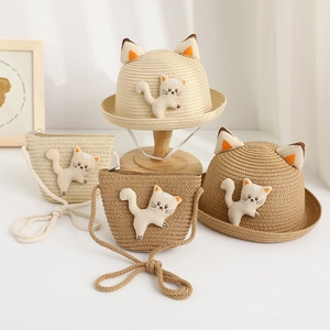 Detail of straw hat and matching bag set for kids with cute cat ears and plush patch