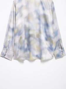Detailed macro view of tie-dye satin shirt cuffs with elegant matching buttons
