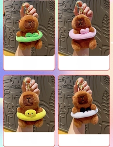 Detail of four capybara plush keychains with animal swim rings and golden metal clips