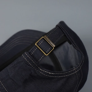 Detail shot of a retro baseball cap showing the adjustable metal buckle and strap.
