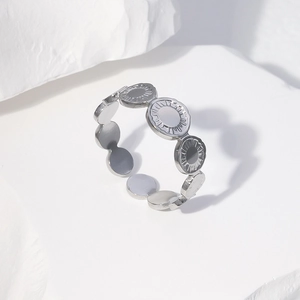 Detailed shot of silver stainless steel ring with radial sunburst pattern textured discs