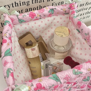 Detail of pink floral fabric storage basket with quilted design and polka dot lining