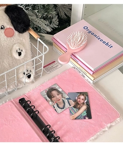 Pink plush binder with clear sleeves showing K-pop photo cards and cute fluffy puppy bag