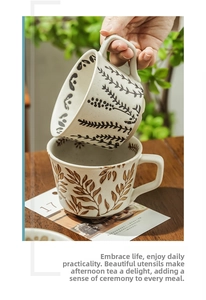 Detail of hand-painted ceramic mugs with leaf patterns and rustic black speckles
