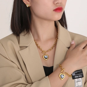 Three-piece gold jewelry set with heart-shaped grey crystal pendants and T-bar toggle clasp