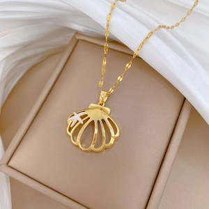 Macro shot of gold shell pendant with starfish detail on a silk jewelry box cushion