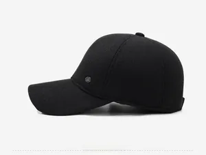 Detailed side view of a black winter baseball cap featuring a decorative metal emblem
