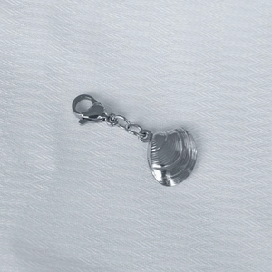 Detail of silver shell pendant with lobster clasp and metal chain on textured fabric