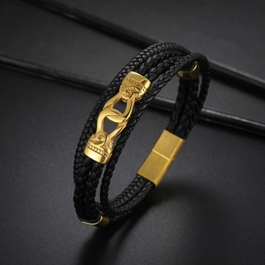 Détail d'un bracelet multicouche en cuir tressé avec fermoir magnétique doré poli