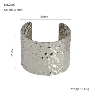 Macro detail of 55mm wide stainless steel cuff bracelet with irregular hammered texture