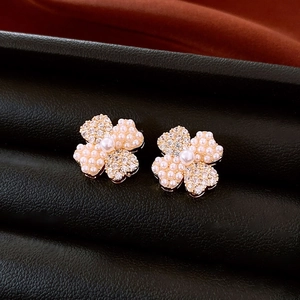 Detailed macro view of 14K gold plated flower stud earrings with pearls and crystals