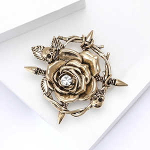 Macro shot of retro alloy skull and rose brooch with crystal center on a white background