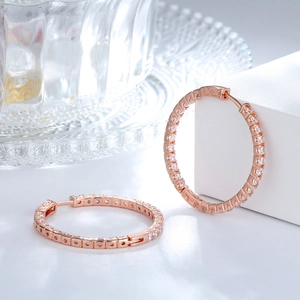 Macro detail of rose gold hoop earrings with pavé set white cubic zirconia crystals