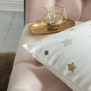 White Christmas pillow cover with gold foil stars on pink sofa with invisible zipper