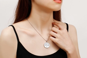 Silver Tree of Life necklace worn by a model against a clean minimal background