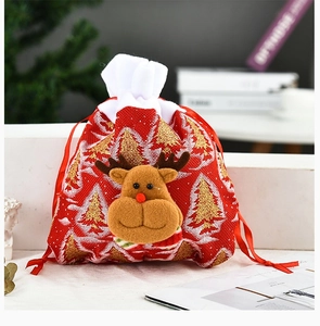 Detail showing 3D reindeer decor and gold Christmas tree prints on red drawstring gift bag
