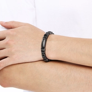 Gros plan d'un bracelet en acier inoxydable gris fusil mat sur un poignet d'homme