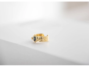 Macro detail of 18K gold plated hammered ring with teardrop black stone setting