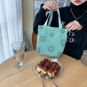 Detail of mint green corduroy tote bag with smile print and vintage metal snap button