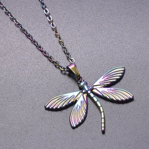 Macro shot of dragonfly pendant with rainbow electroplating and detailed wing engraving