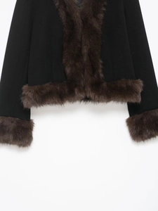 Detail of black wool jacket with brown faux fur trim on the hem and cuffs for winter