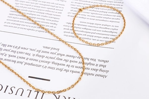 Close-up of minimalist 18k gold-plated titanium steel chain necklace and bracelet set
