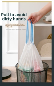 Detail of white drawstring trash bag with blue handles showing automatic closure design