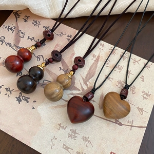 Ethnic handmade wooden necklace with gourd and heart pendants on wax cord strap
