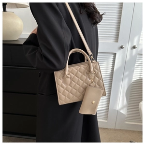 Detail of beige quilted square handbag featuring a mini coin purse and long shoulder strap