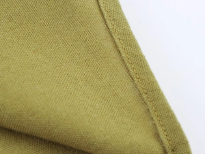 Detailed macro view of linen-blend fabric texture and precision stitching on the garment