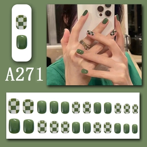 Detail of green and white checkerboard press-on nails with full 24-piece set layout