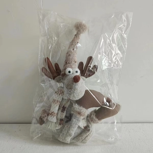 Detail eines braun-beige gestrickten Weihnachts-Rentiers mit Schal und Mütze