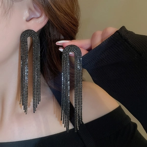 Detailed close-up of long black teardrop tassel earrings with sparkling rhinestones