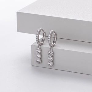 Close-up of S925 sterling silver hoop earrings with triple stone drop pendants