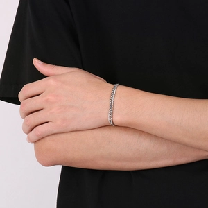 Close-up of a silver Cuban link chain bracelet on wrist with polished stainless steel finish