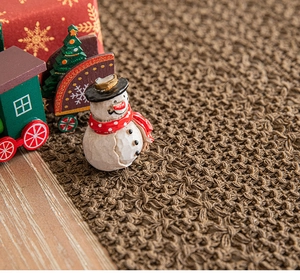 Close-up of brown woven festive table runner texture with blurred holiday ornaments
