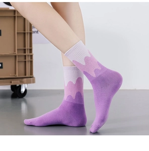 Detail of gradient purple wave-patterned mid-calf socks with ribbed knit texture