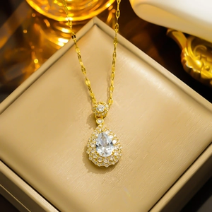 Golden teardrop emerald-style zircon necklace in a premium beige jewelry box display