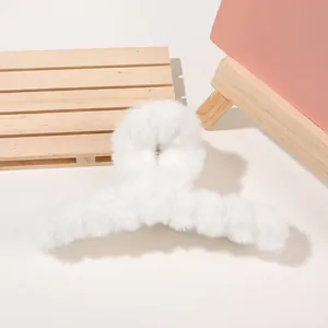 Close-up of a large white plush hair claw clip showing soft faux fur texture for women