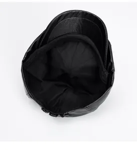 Detail view of the black PU leather newsboy cap showing the neat fabric inner lining