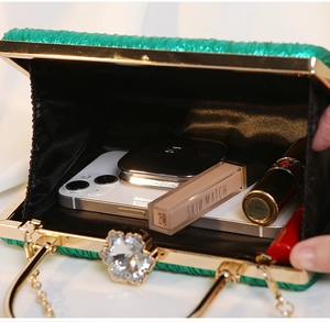 Interior view of pleated emerald green evening bag showing space for phone and makeup