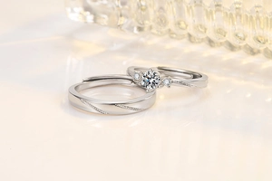 Macro shot of silver couples rings featuring a four-claw moissanite setting and textured band