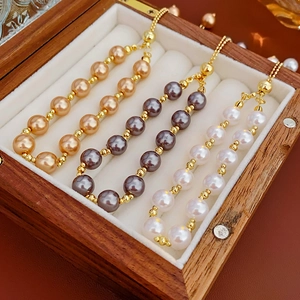Detailed close-up of three pearl bracelets in white grey and champagne on velvet lining