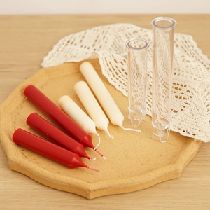 Slim candle mold set with red and beige tapered candles on a rustic wooden tray