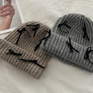 Winter knitted beanie with velvet bows in grey and khaki colors with a ribbed texture