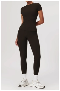 Full body shot of a woman in dark brown slim-fit yoga set with high-waist sports leggings